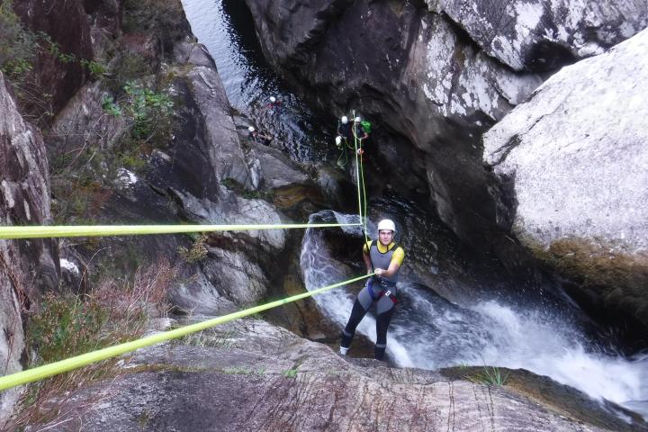 a man standing next to a waterfall